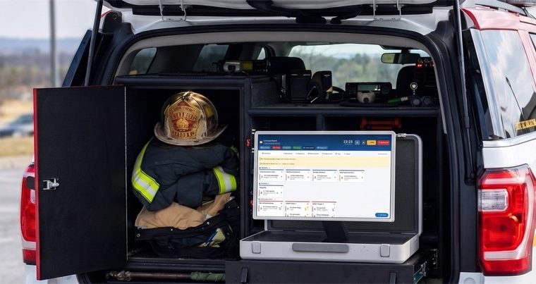 Das Fahrzeug eines Einsatzleiters mit offener Heckklappe: ein Helm und Schutzkleidung neben einem Laptop mit CERES